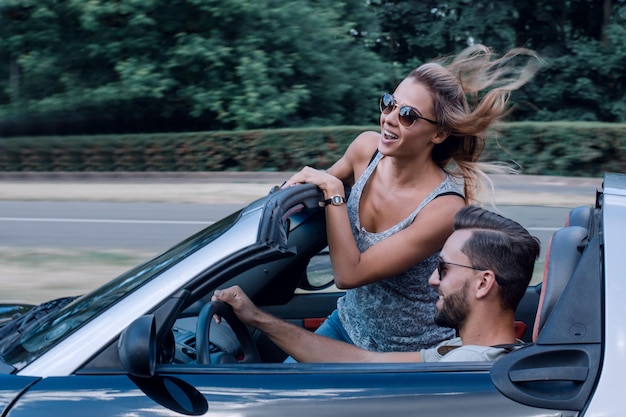 Couple of lovers driving on a convertible car Newlywed pair on a romantic date