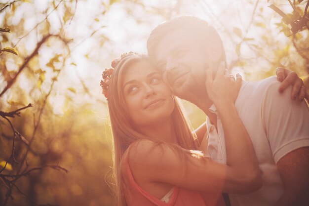 Amanti delle coppie che si abbracciano e si baciano nel parco al tramonto concetto di felicità giovanile d'amore