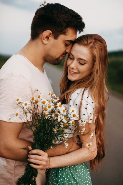 Couple of lovers in the middle of a country road holding each other by hand portrait of a girl with ...