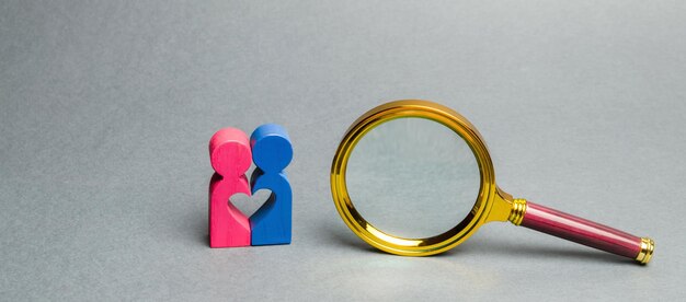 Photo couple of lovers standing near a magnifying glass the concept of finding love and dating