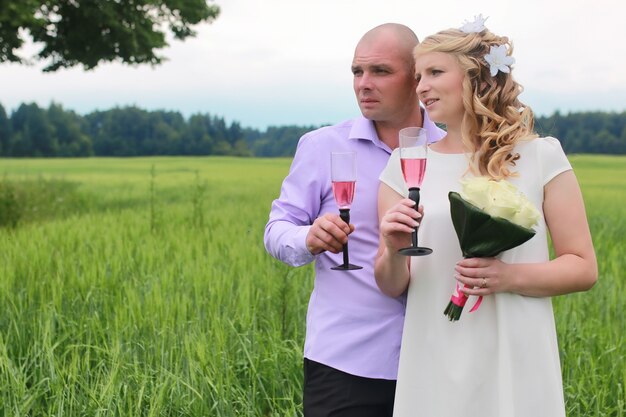 Couple lovers walking in a green field in summer day