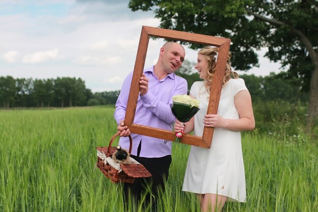 Couple lovers walking in a green field in summer day