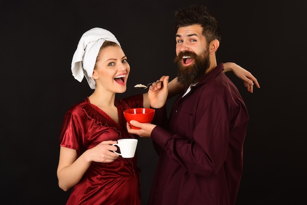 Couple. Loving couple having breakfast smiling at each other. Concept of love, home, food, lifestyle. Happy loving couple enjoying breakfast isolated. Romantic couple eating cereals, drinks coffee.