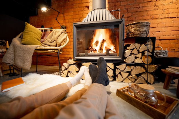 Couple lying by the burning fireplace in a cozy house in loft style
