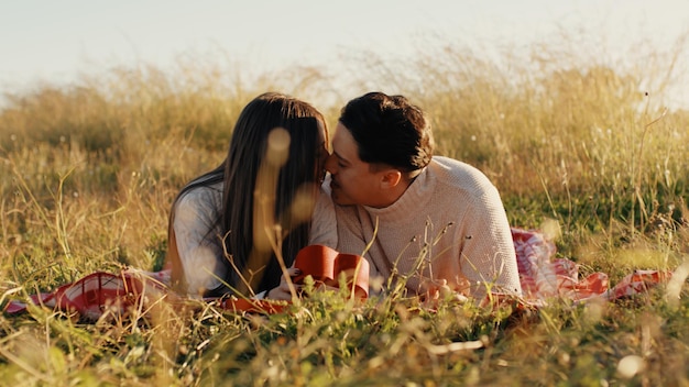 Photo couple lying on the grass is kissing each other