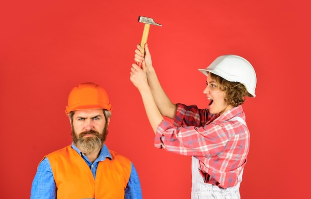 Couple making repair at home Home Renovation Rub in Couple knocking head with hammer Clearly explain Intelligibly concept Couple renovating apartment together Man and woman wear safety helmet