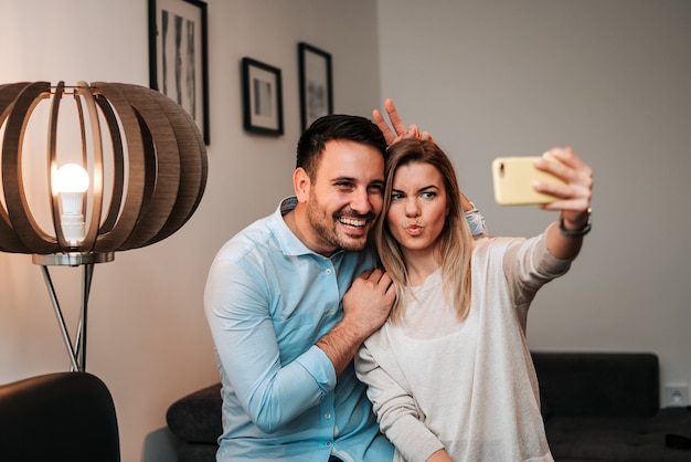 Couple making selfie at home. Having fun.