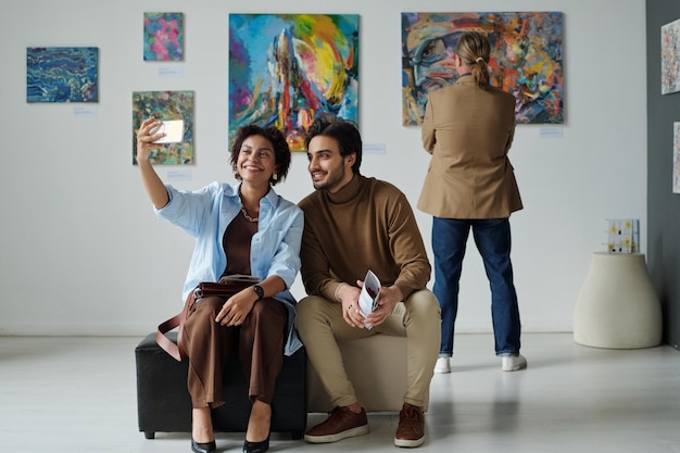 Couple making selfie portrait in gallery