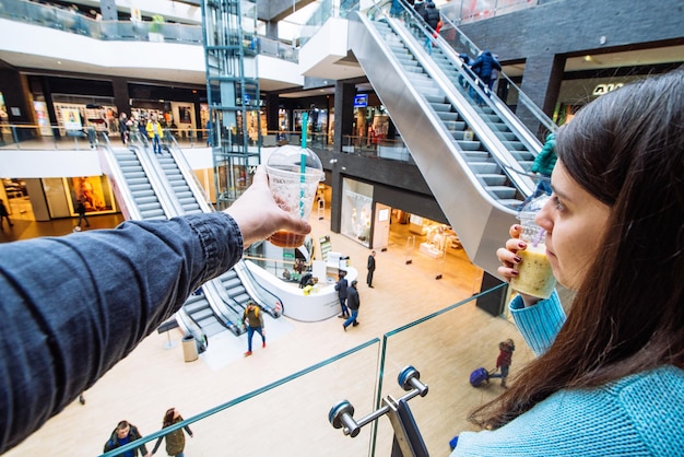 モールのカップルが買い物をします。スムージーを飲む。ライフスタイルのコンセプト