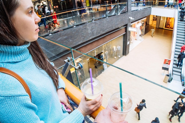 Foto le coppie nel centro commerciale fanno il concetto di stile di vita dei frullati della bevanda dello shopping