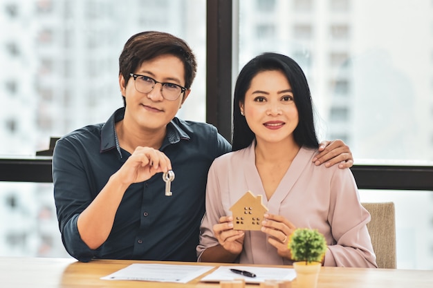 Couple man holding Key and Women holding home model for buying home concept
