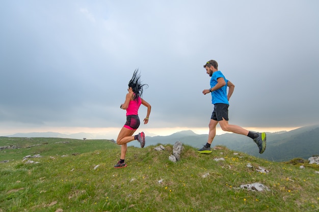 Couple of man and woman mountain athletes runners in action