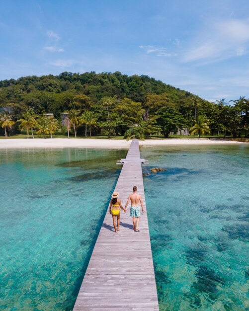 Couple man and women on wooden board walk of a tropical island in thailand koh kham near koh mak