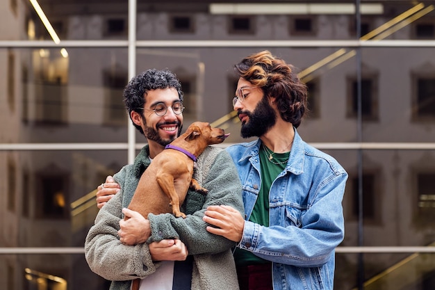 Couple of men embracing with their loving little dog