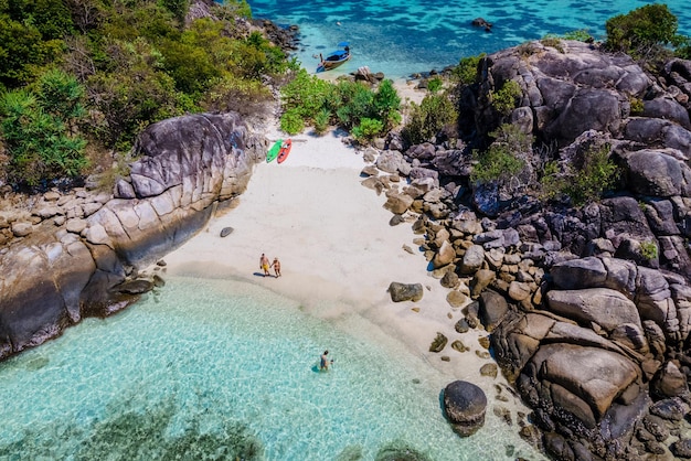 couple of men and woman on the beach of Kla Island in front of Koh Lipe Island Southern Thailand