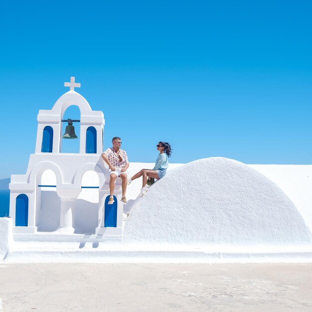 Couple men and woman on vacation santorini greece young couple on vacation in greece