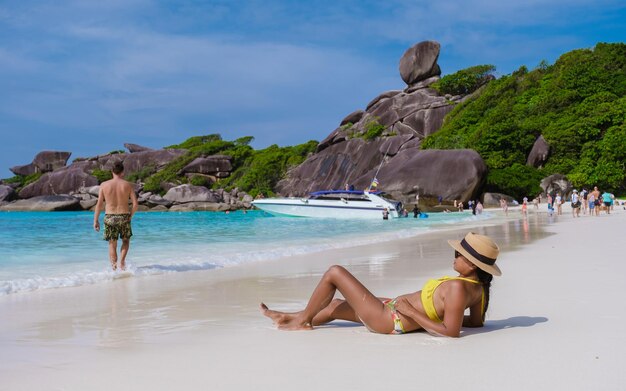 Couple of men and women on a trip to the tropical island with\
white beach similan islands thailand