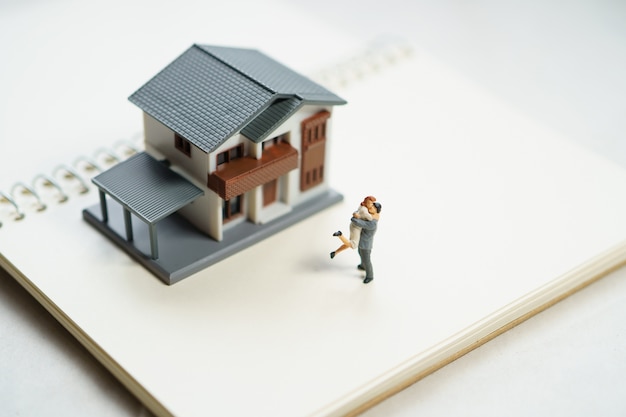 Couple Miniature 2 people standing model with house model make family Feel happy.