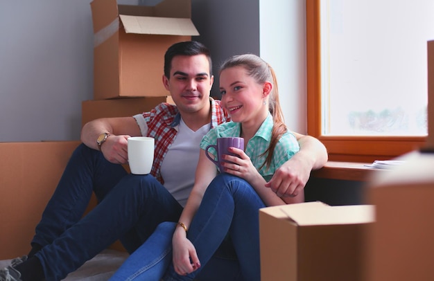 Couple moving in house sitting on the floor Couple