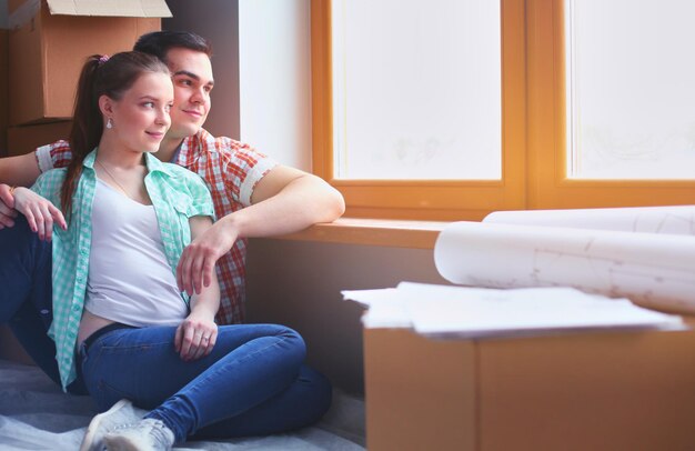 Couple moving in house sitting on the floor Couple