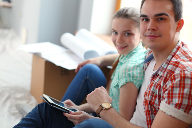 Photo couple moving in house sitting on the floor