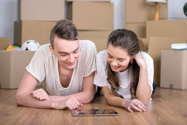 Couple moving in together relaxing on floor.