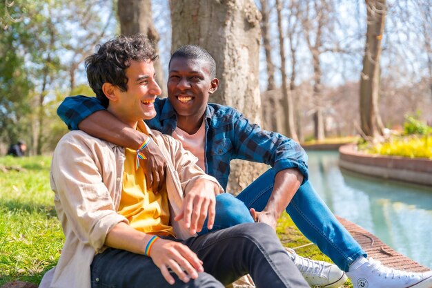 Coppia di uomini gay multietnici che parlano tranquillamente nel concetto lgbt del parco