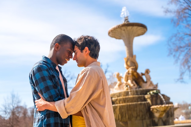 Couple of multiethnic men in a city fountain lgbt concept in a romantic pose