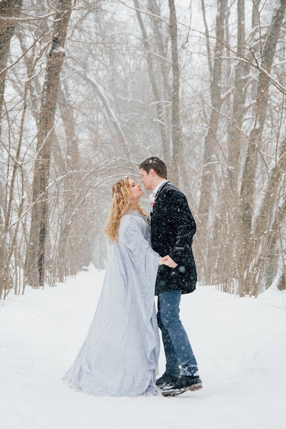 Couple on nature in winter during a snowfall