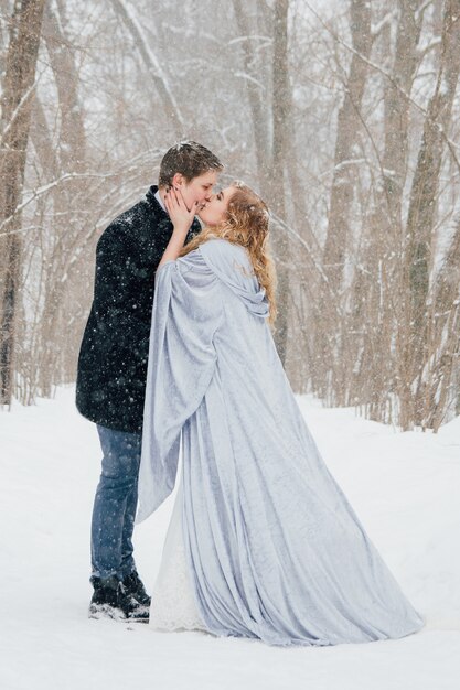 Couple on nature in winter during a snowfall