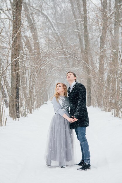 Couple on nature in winter during a snowfall