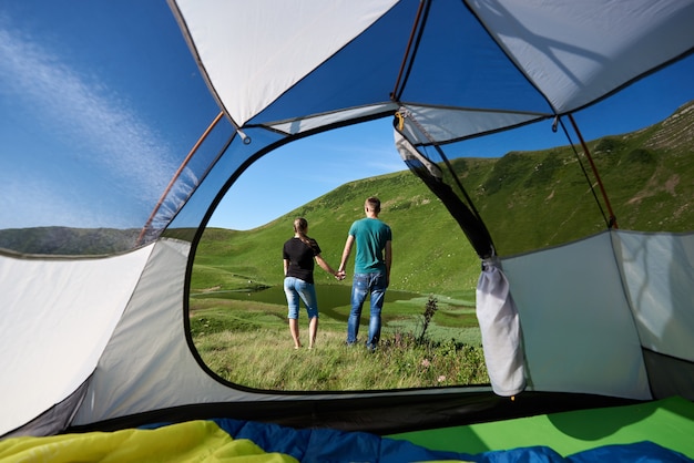 Couple near tourist tent enjoying in the mountains