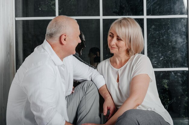 couple near the window hugging, kissing and smiling