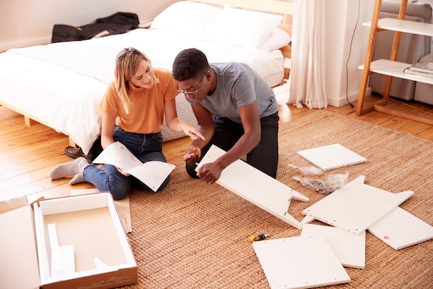 Couple In New Home Putting Together Self Assembly Furniture