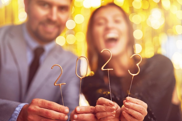 Couple at new year eve party with 2023 sparklers