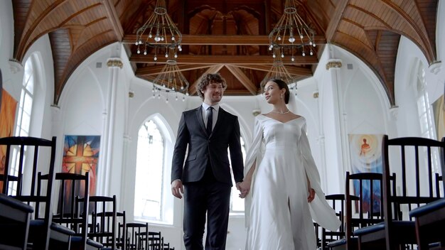 A couple of newlyweds walking quickly through the temple action a beautiful bride in a white tight