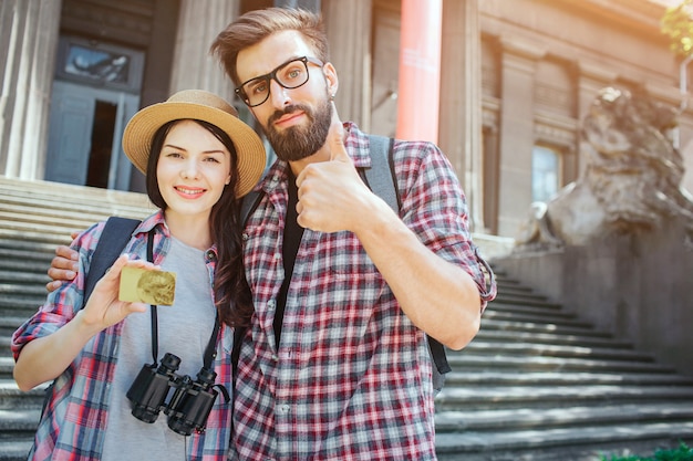 写真 若い観光客のカップルが階段でoutisdeに立ち、カメラでポーズ