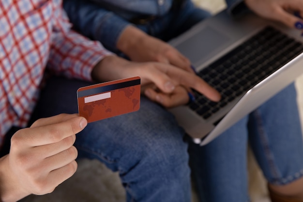 Couple online shopping concept. Credit card in the hand. Using computer.