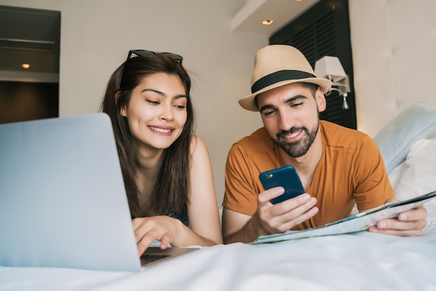 Coppia organizzando il loro viaggio in camera d'albergo.