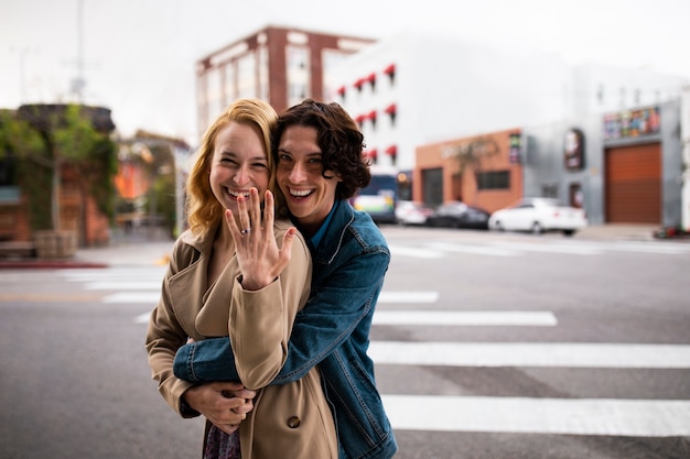 Foto coppia all'aperto in città dopo la proposta con anello di fidanzamento