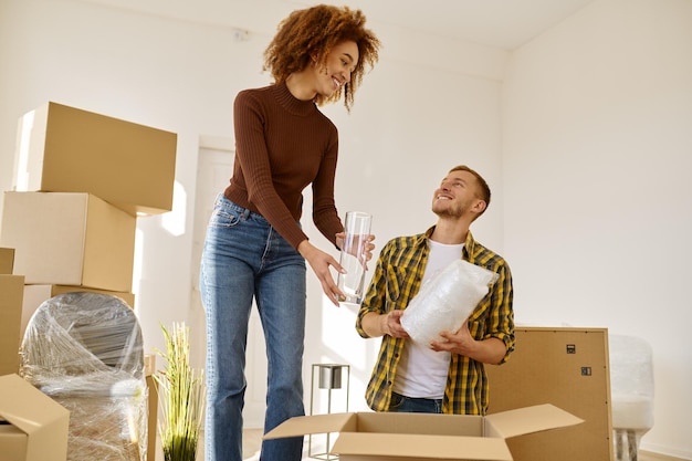 Couple packing stuff among plenty of boxes