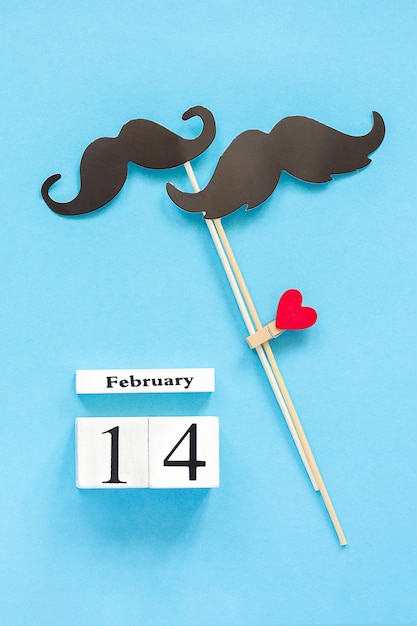 Couple paper mustache props fastened clothespin heart and calendar February 14 