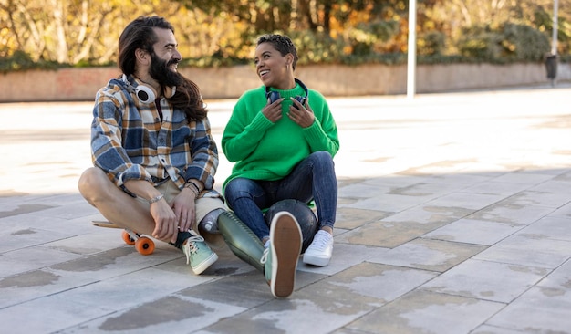 Couple in the park young hispanic woman and man with amputated leg and prosthesis