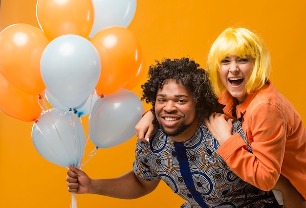 Photo couple at party having fun and holding balloons