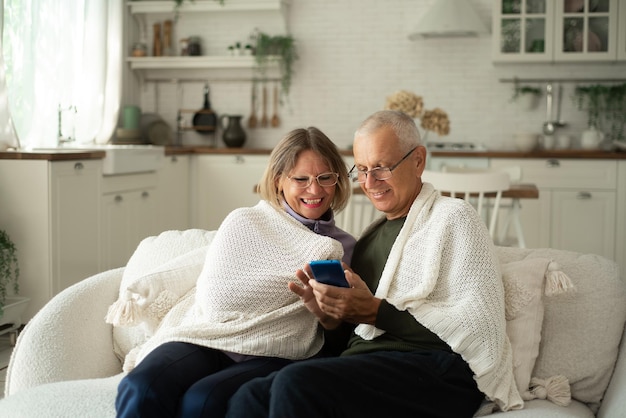 A couple of pensioners are warming up and sharing news at home on the couch