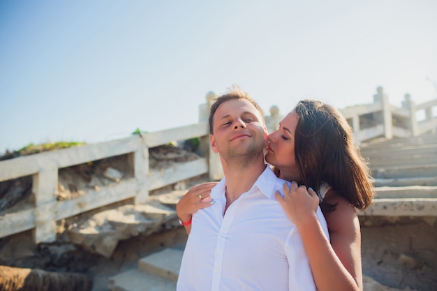 Couple photographed on vacation sea, ocean. Against background destroyed Vietnamese staircase