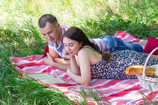 Couple on a picnic. guy and girl are lying and reading book