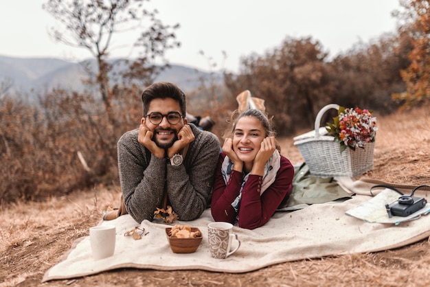 Couple at picnic lying down on the blanket with head in hands