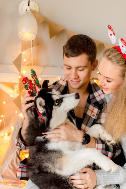 Couple playing with dog in bedroom