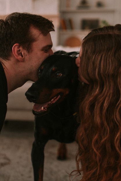 Couple playing with dog in bedroom